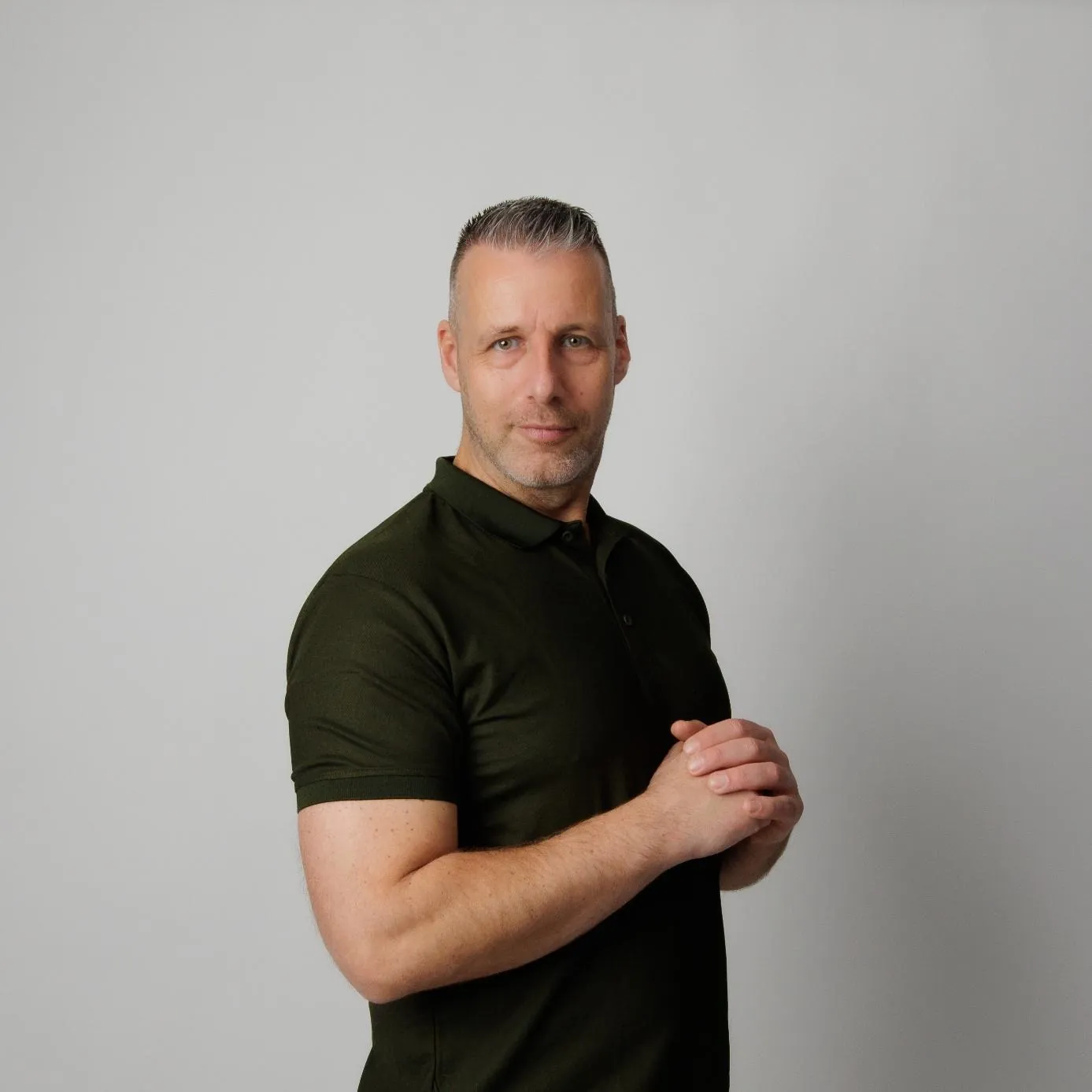 Maikel Menkhorst in een olijfgroene polo, de handen voor zich gevouwen