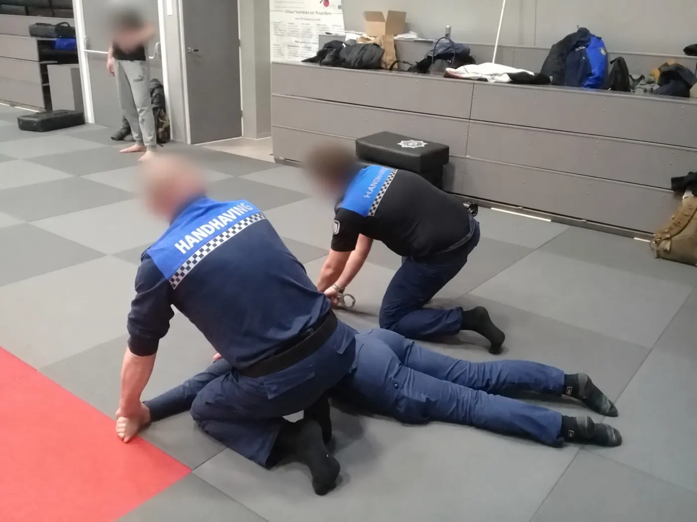 Handhavers oefenen een aanhouding op de mat