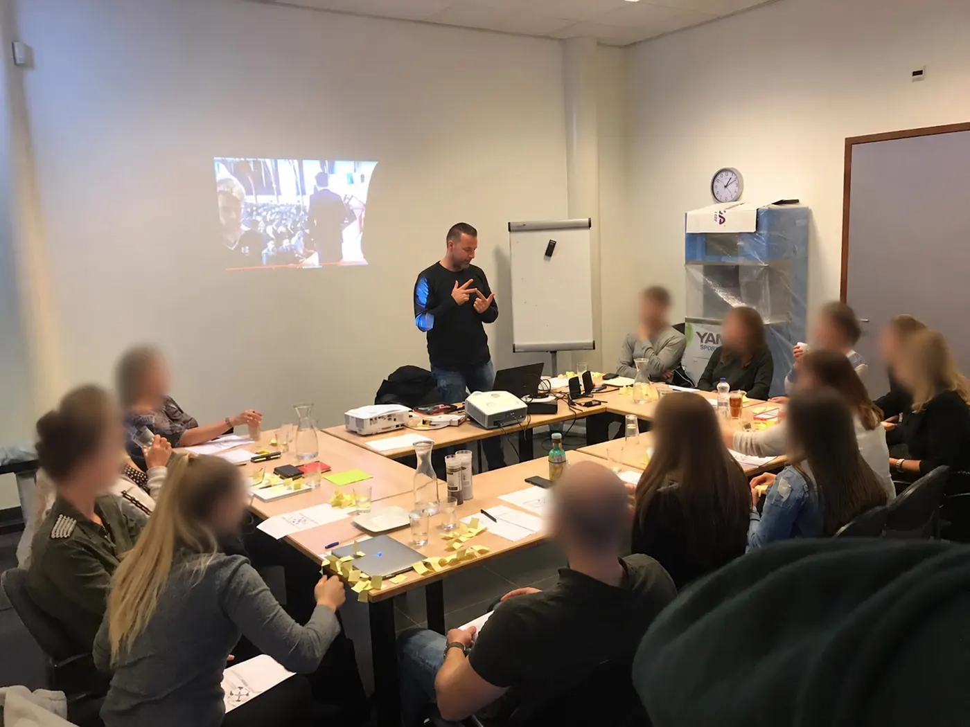 Maikel geeft uitleg aan een groep deelnemers in een trainingsruimte